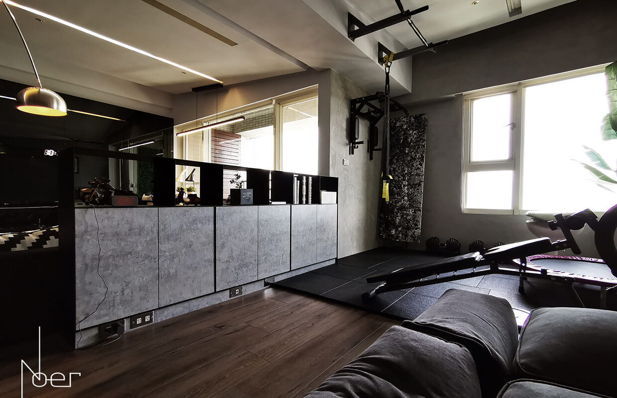 利用鐵板烤漆櫃分隔客廳與健身區，既有空間區劃的功能且不阻隔視線穿透。