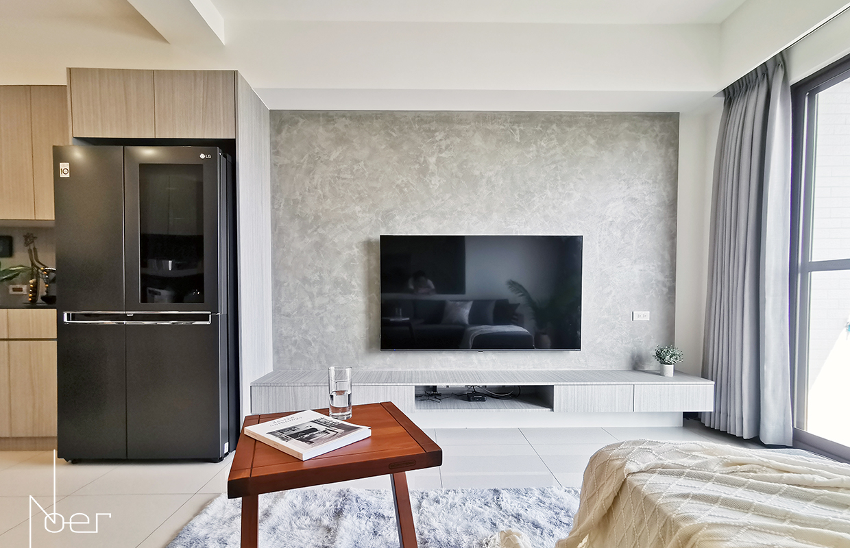 電視牆僅以灰泥塗料來搭配淺色木作櫃體以及實木家具，迎合屋主喜好簡約風格的同時也節省了裝潢預算。