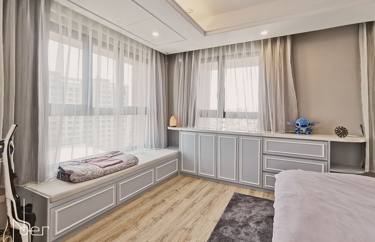主臥大量開窗的區域設計了L型的收納矮櫃及起居空間，並以灰藍色調帶出臥室的沉靜氛圍。